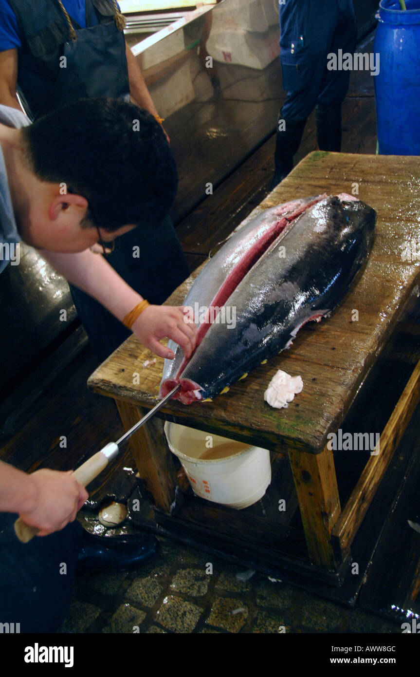 Lavoratori sfilettatura Tonno al mattina presto il mercato del pesce a Tokyo Giappone Foto Stock