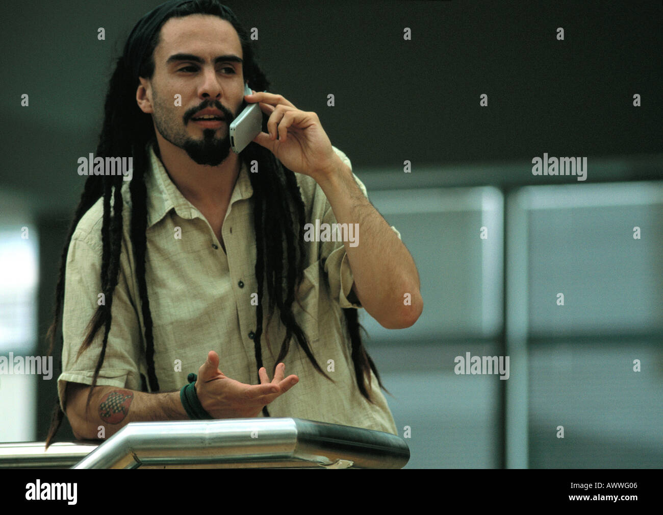 L'uomo parlando al cellulare, appoggiata contro la rotaia Foto Stock