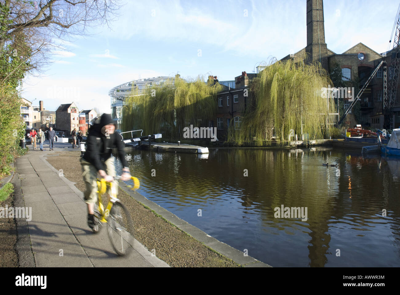 Un ciclista viaggia lungo un canale a Hackney, a est di Londra, Regno Unito Foto Stock