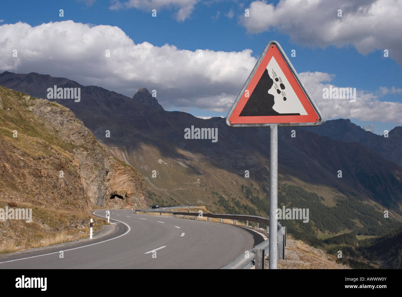 Bendy road e caduti rock segno di traffico nella valle del Bernina svizzera Foto Stock