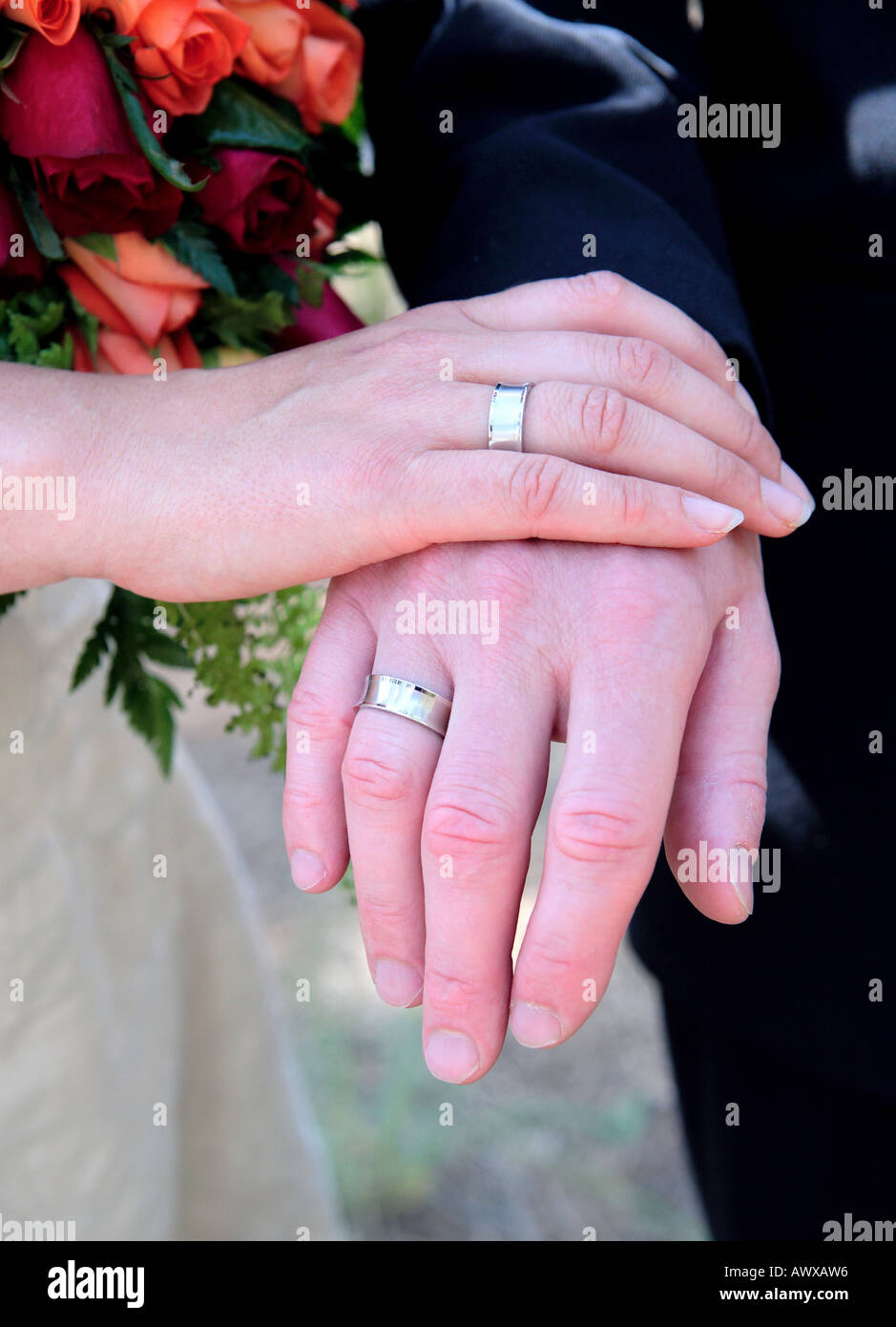 Novelli sposi mani mostrare gli anelli di nozze e bouquet di fiori Foto Stock