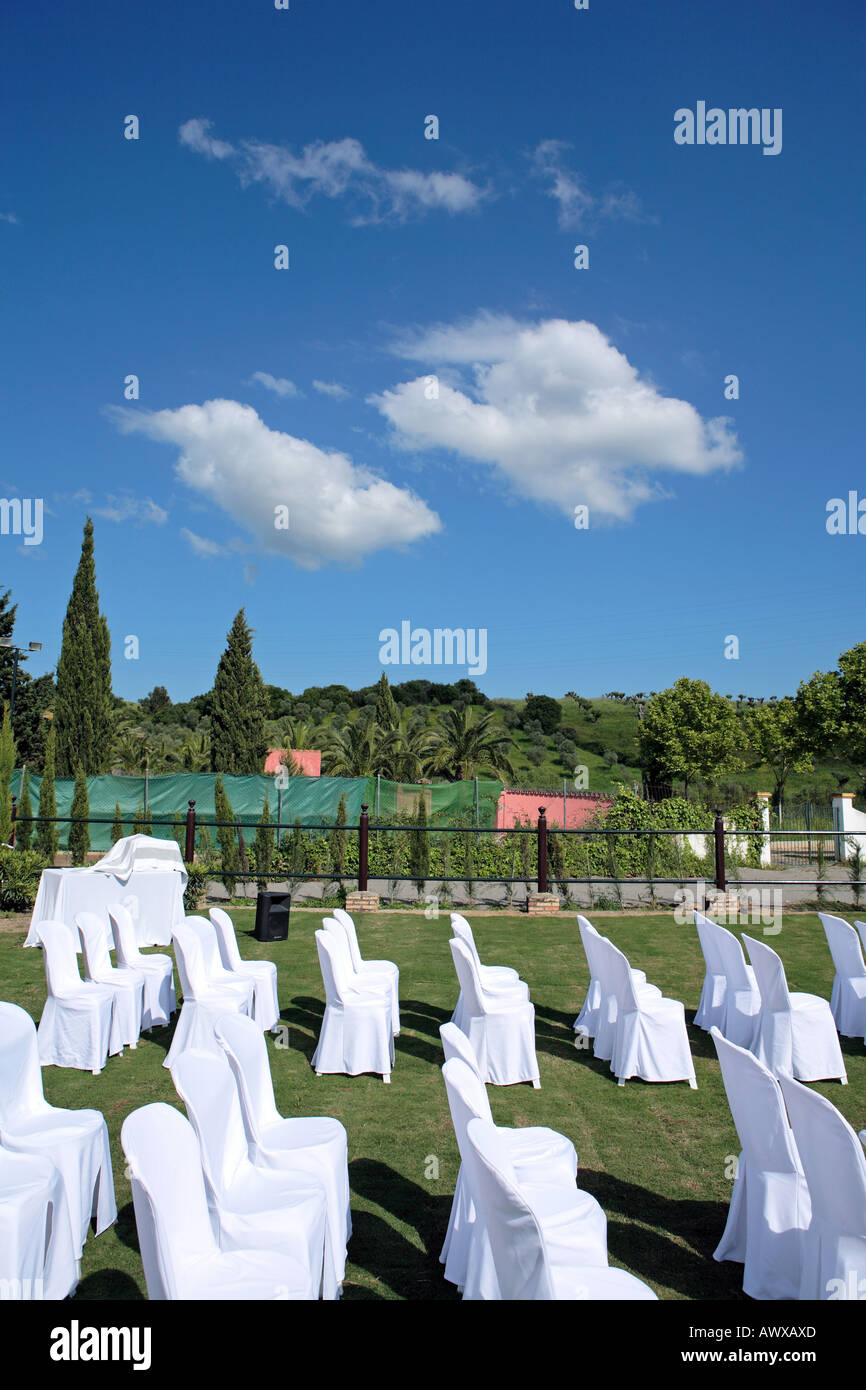 Svuotare sedili bianchi a un matrimonio all'aperto al sole Foto Stock