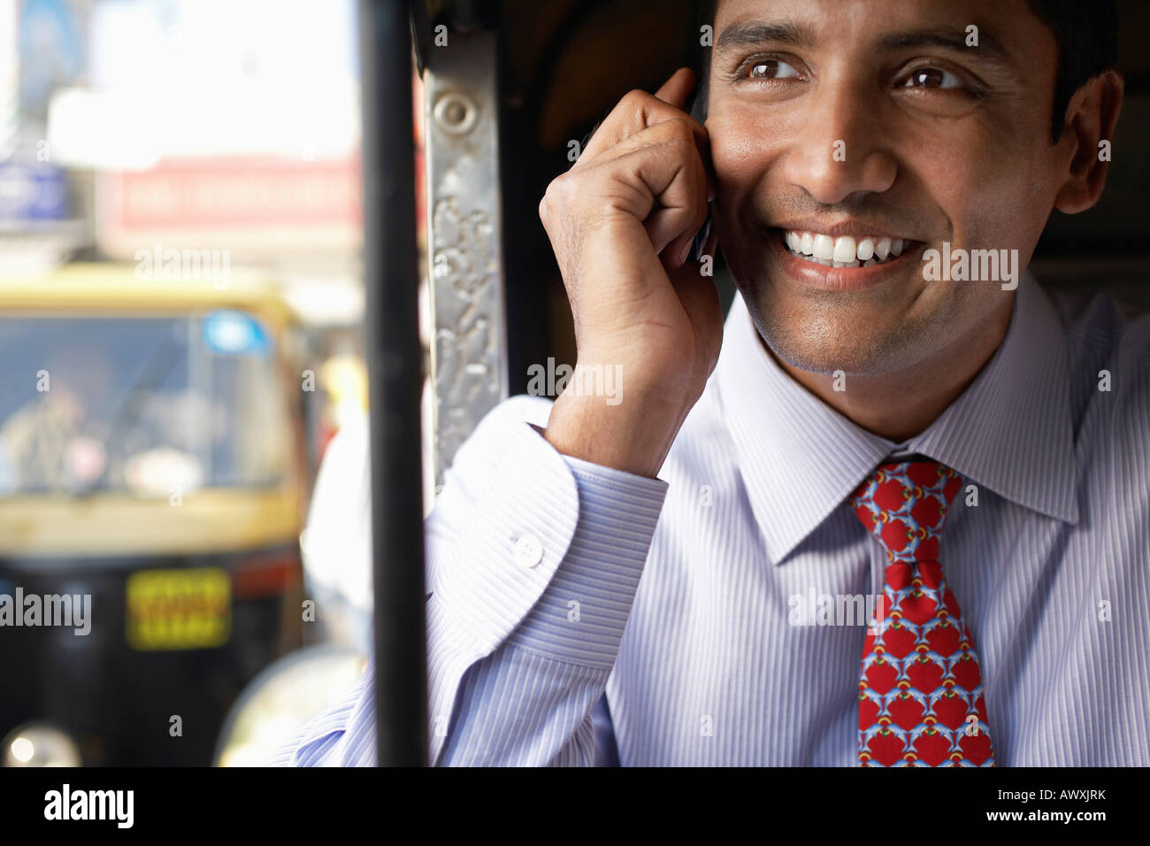 Uomo d'affari tramite telefono cellulare, sorridente Foto Stock