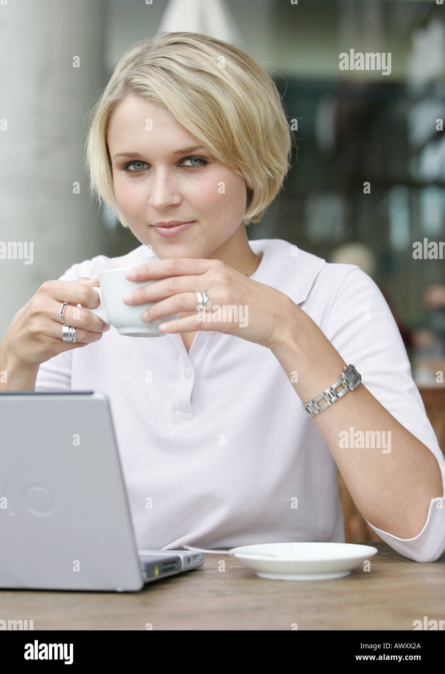 Giovane donna di affari con computer portatile in un coffee shop Foto Stock