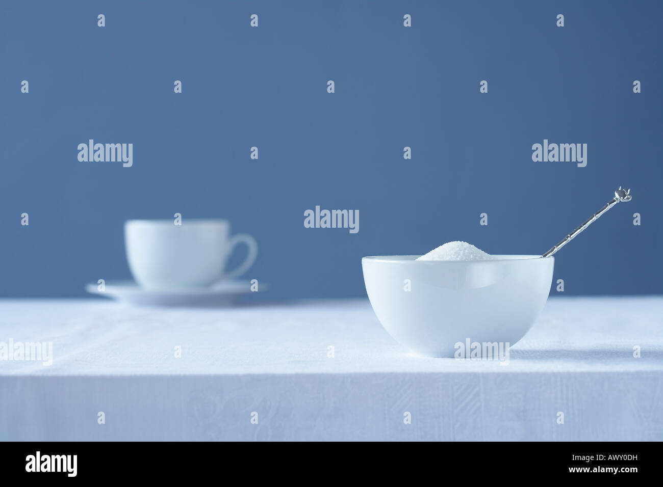 Ciotola di zucchero sul tavolo, tazza da tè in background Foto Stock