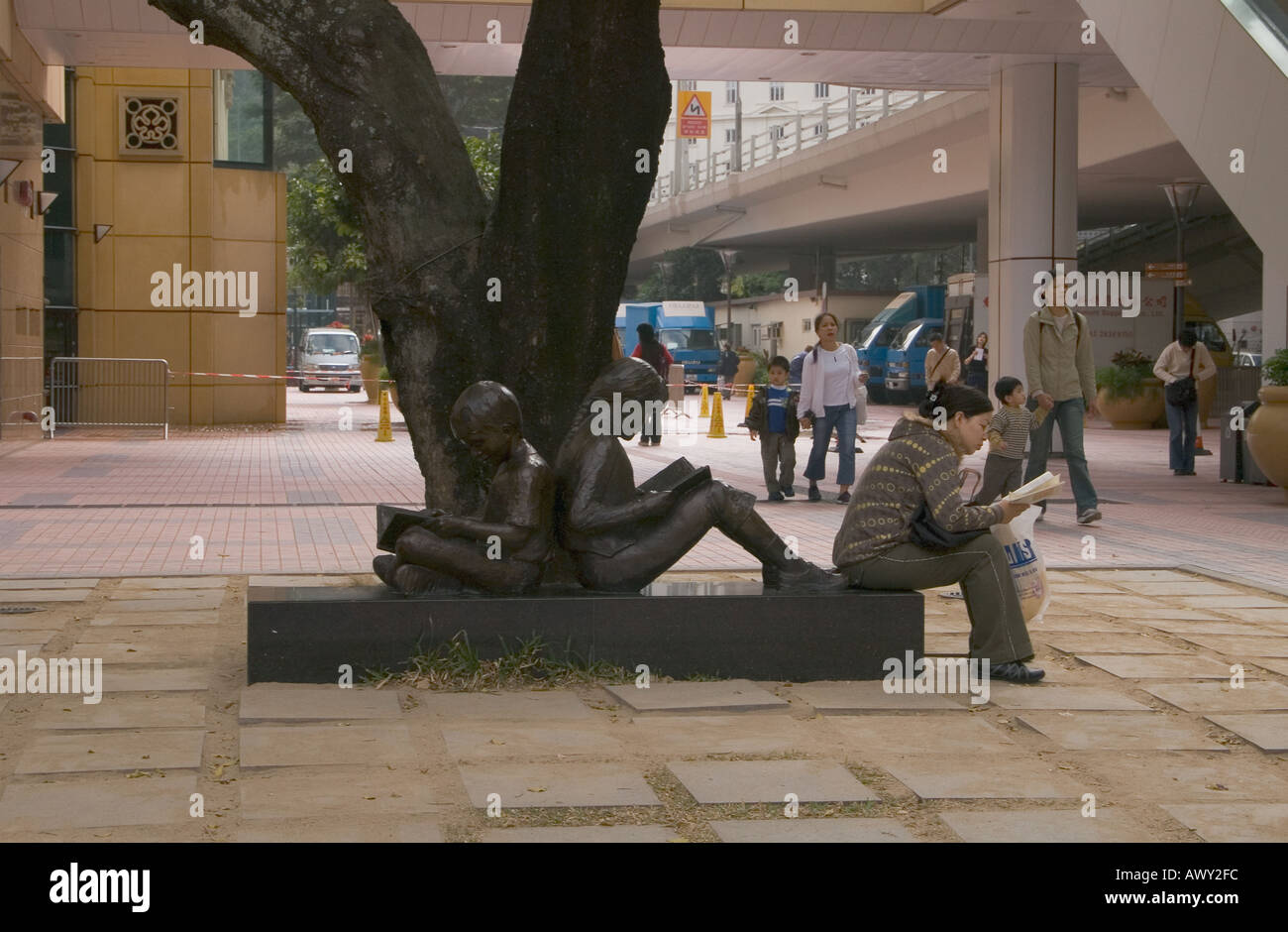 dh Hong Kong Central Library CAUSEWAY BAY HONG KONG cinese donna lettura libro statua di due bambini libri hk ragazza gente di scultura d'arte della cina seduta Foto Stock