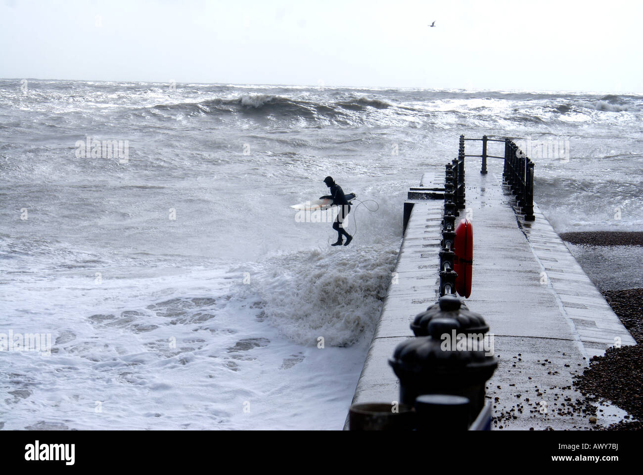 Surfer salti in condizioni di mare grosso off Hastings Foto Stock