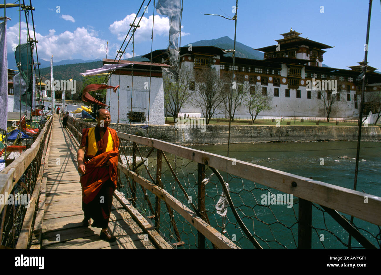 Monaco attraversando il ponte dal Pungthang Dechen Dzong in Punakha distretto di Bhutan Foto Stock