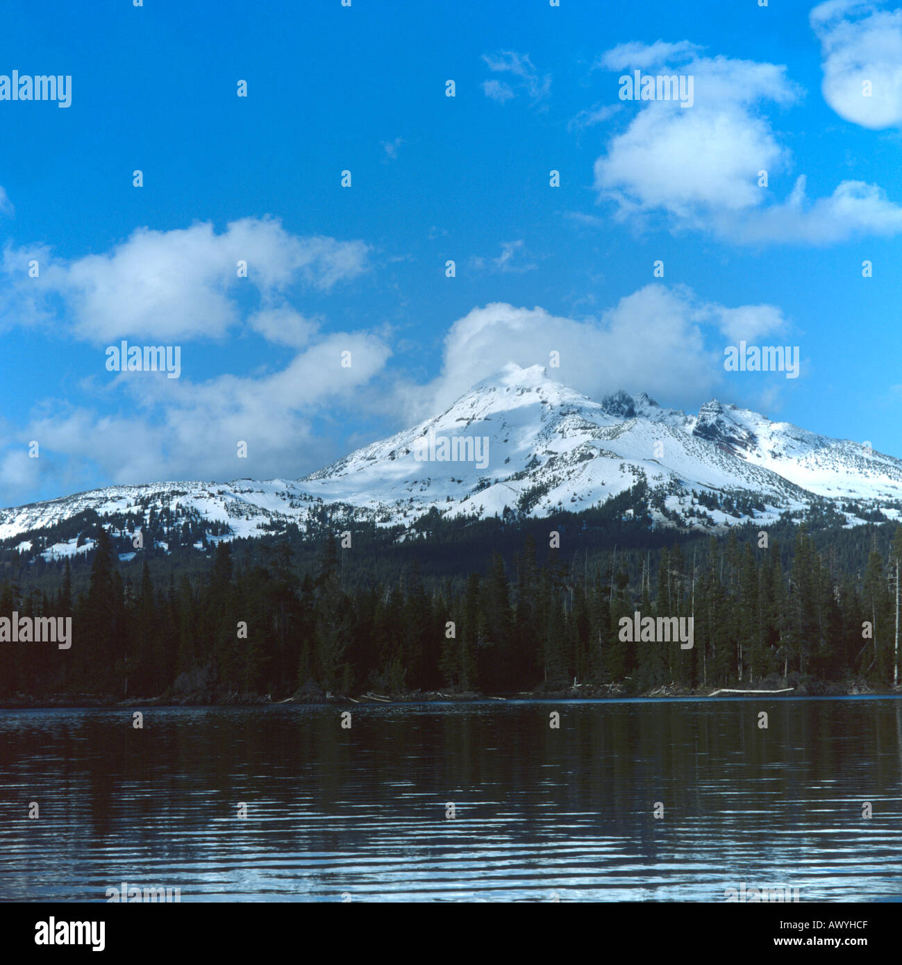 Snow capped mountain rotto in alto sullo sfondo il lago di scintille in primo piano le nuvole tre sorelle deserto Oregon Cascades USA Foto Stock