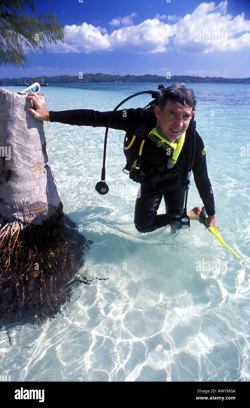 Uomo di mezza età imparando a immersioni nelle limpide acque tropicali di Wakatobi. Il Parco Nazionale Marino di Sulawesi Indonesia MR Foto Stock