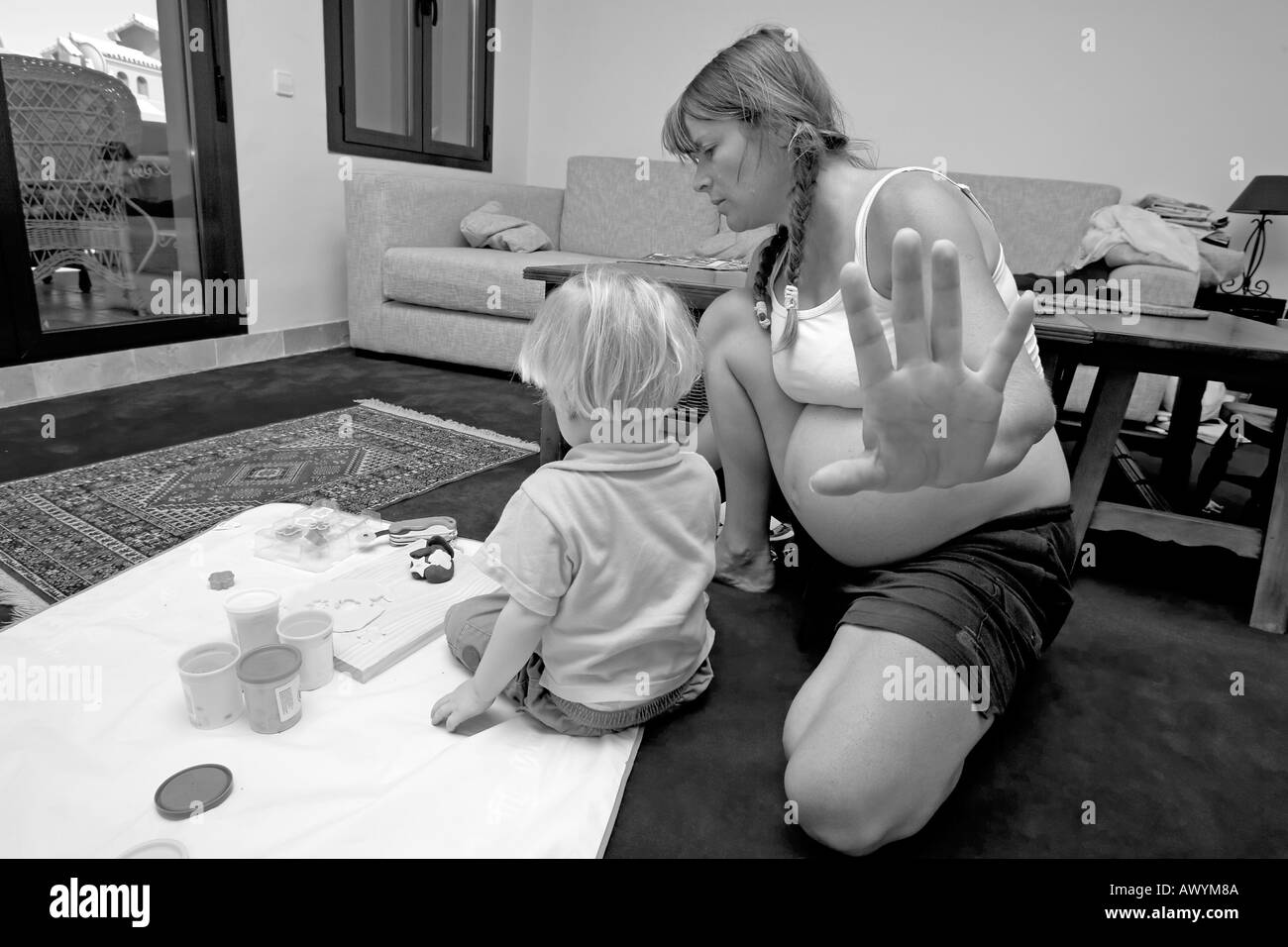 Donna incinta sottolineando e problemi con il suo figlio di 2 anni per gettare un tantrum Foto Stock