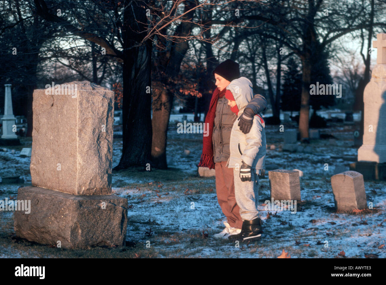 Due giovani orfani stand presso il marcatore di grave dei loro genitori che sono rimasti uccisi in un incidente automobilistico Foto Stock