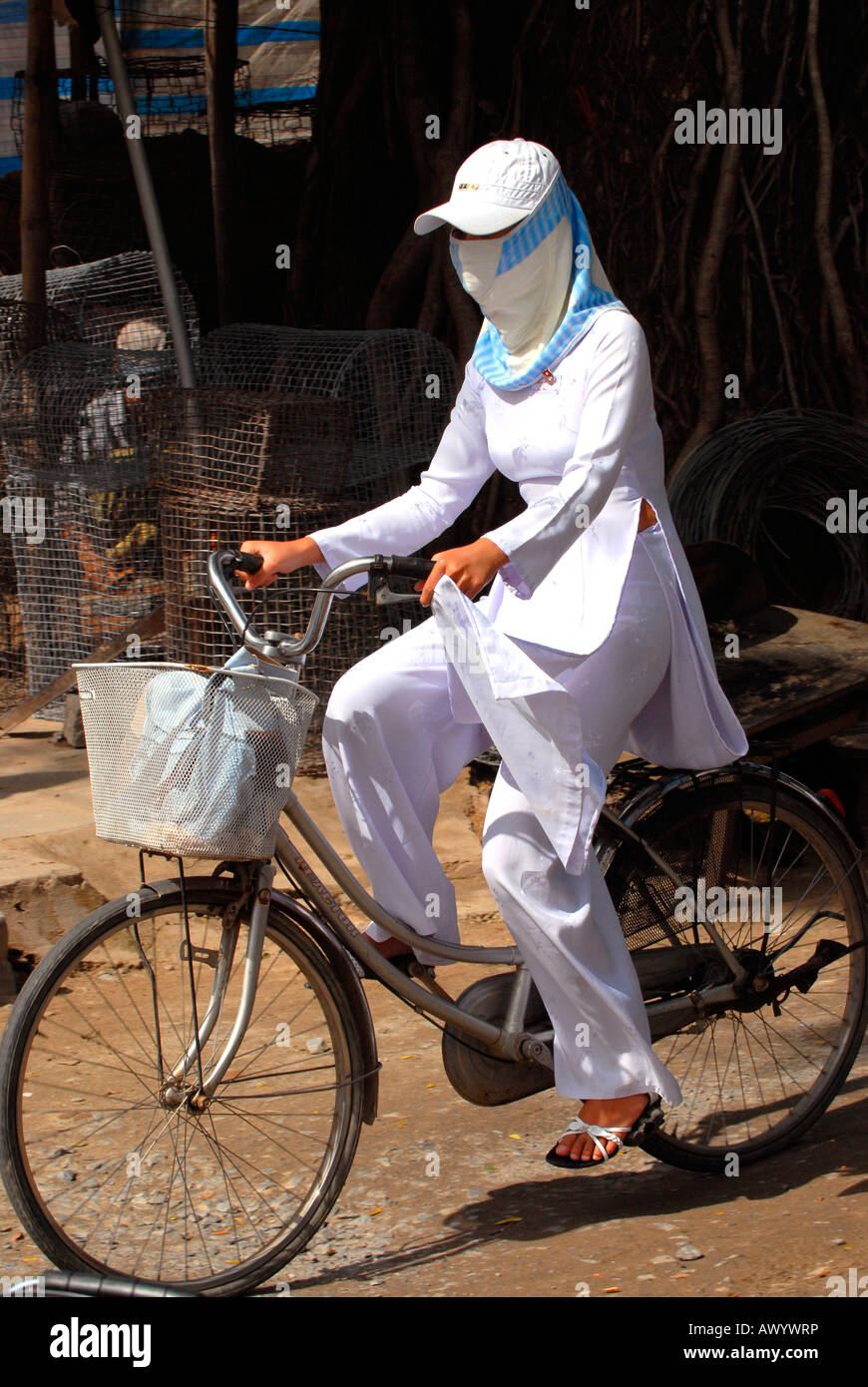 Asia far East Vietnam Hoi un mercato una bella giovane ragazza adolescente equitazione bici tradizionale bianco ao dai scuola maschera uniforme Foto Stock