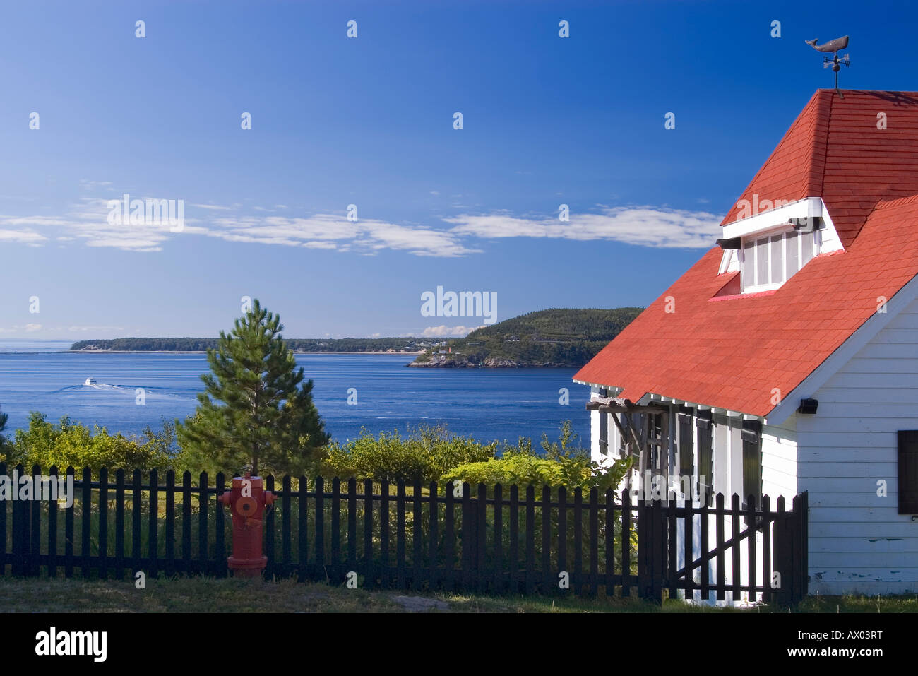 Casa con il tetto rosso con il Fiume Saguenay estuario in background a Tadoussac Foto Stock