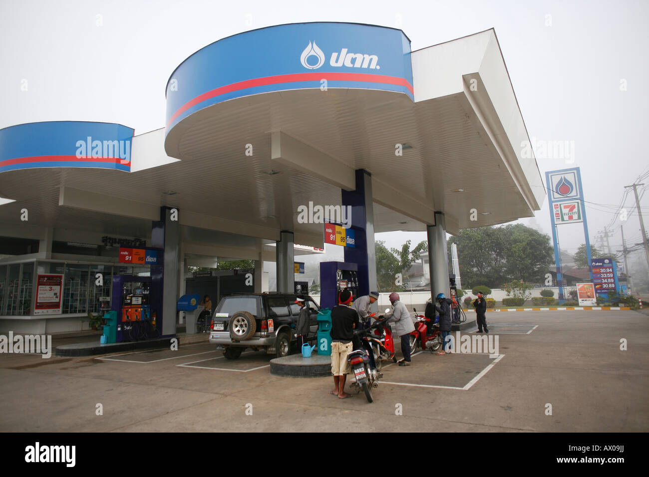 La gente in attesa di riempire i loro serbatoi di gas in corrispondenza di una grande stazione di benzina a Bangkok Foto Stock