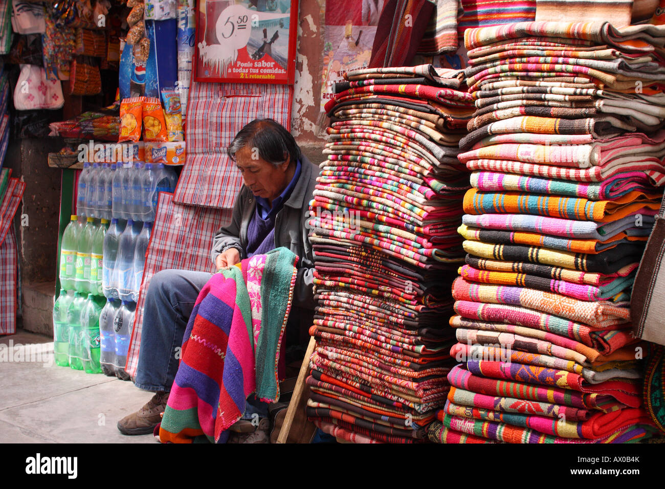 Un uomo mende una coperta per la vendita in streghe " Mercato di La Paz in Bolivia. Foto Stock