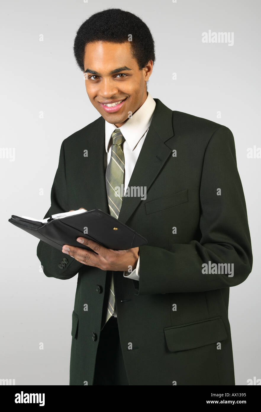Sorridente imprenditore iscritto nel giorno planner Foto Stock