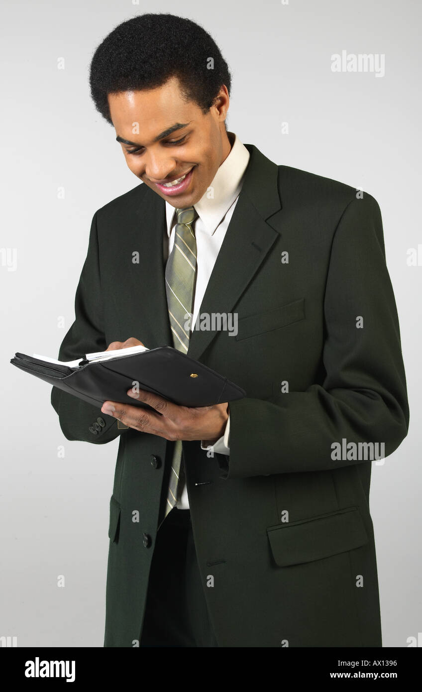 Sorridente imprenditore iscritto nel giorno planner 1459709 uid Foto Stock