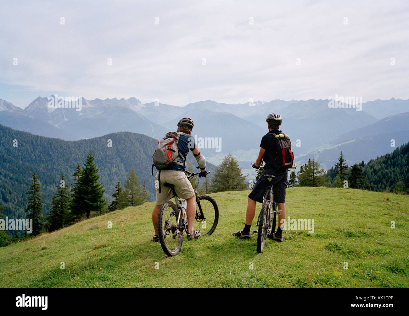 Due ciclisti sulla sommità di una collina a guardare la vista Foto Stock