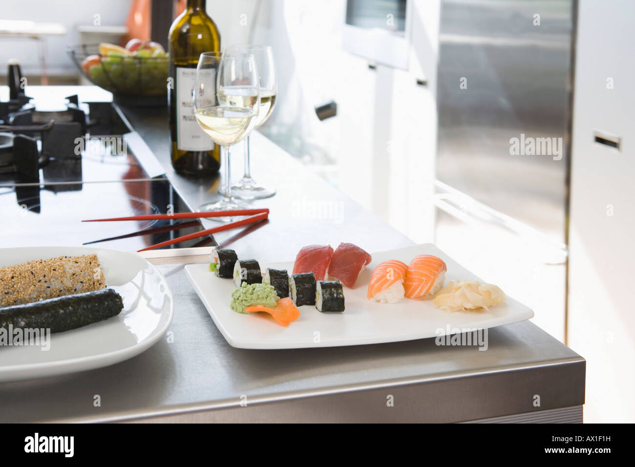Il sushi e il vino bianco su un banco di cucina Foto Stock