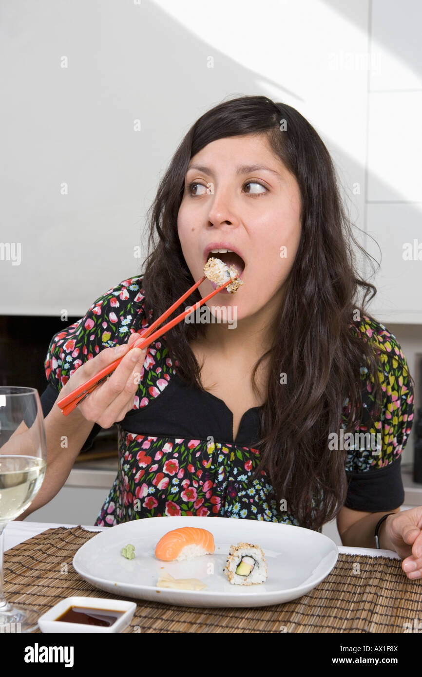 Una giovane donna di mangiare sushi Foto Stock