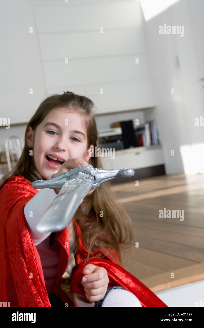 Una bambina tenendo una spada giocattolo Foto Stock