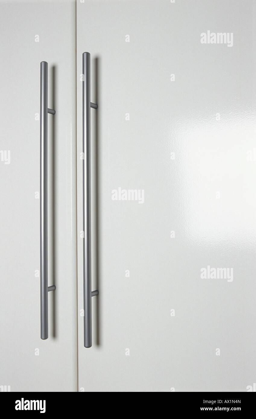 Coppia di chrome guardsman maniglie delle porte su bianco antine Foto Stock