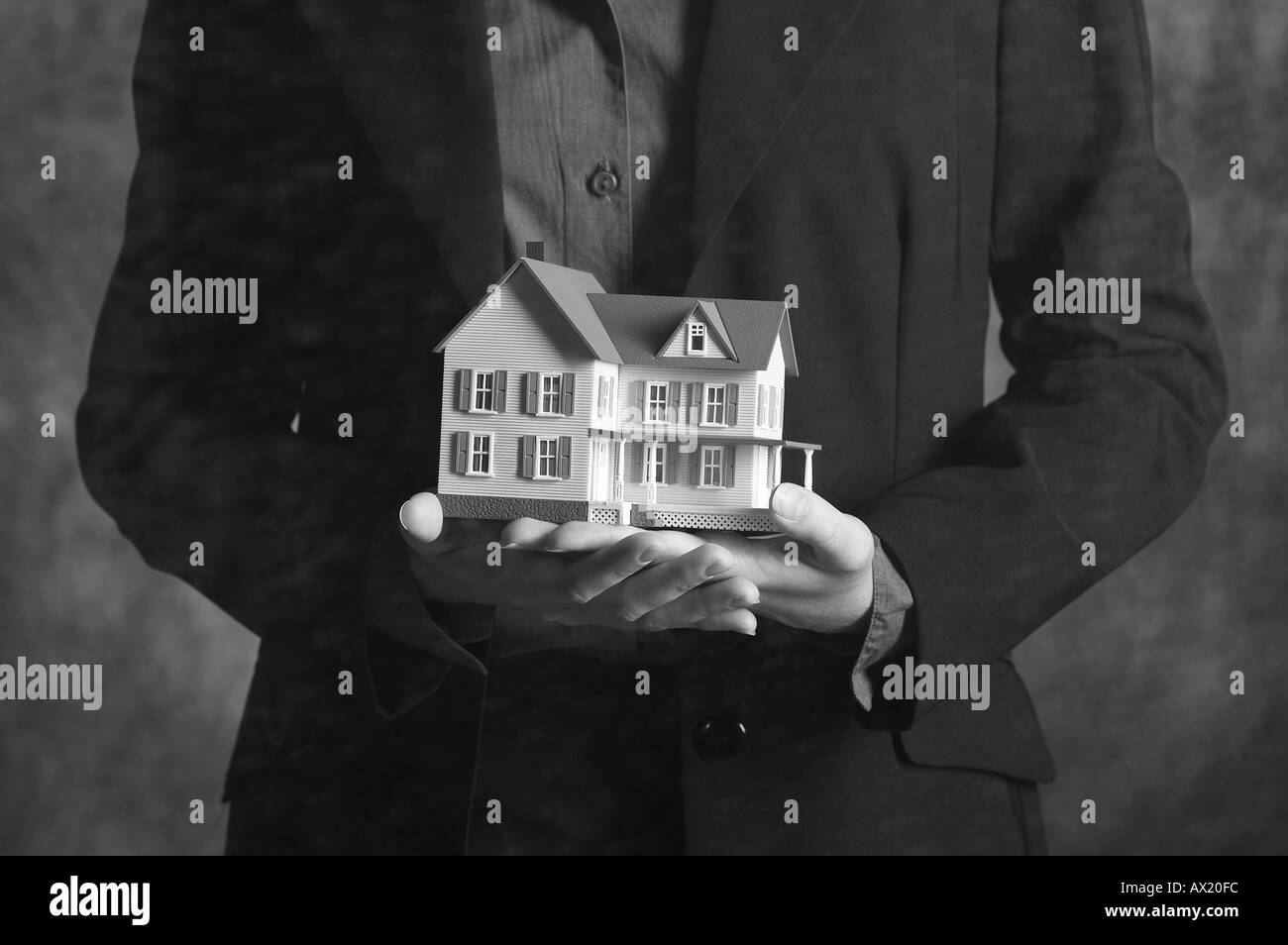 Donna che mantiene modello di casa di essere 3 Foto Stock