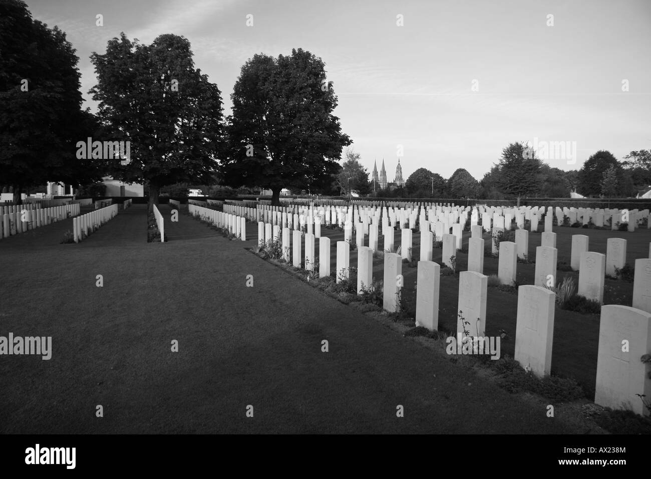 British graves al cimitero del Commonwealth a Bayeux, Normandia con il Bayeux Cattedrale di Notre Dame in distanza. Foto Stock