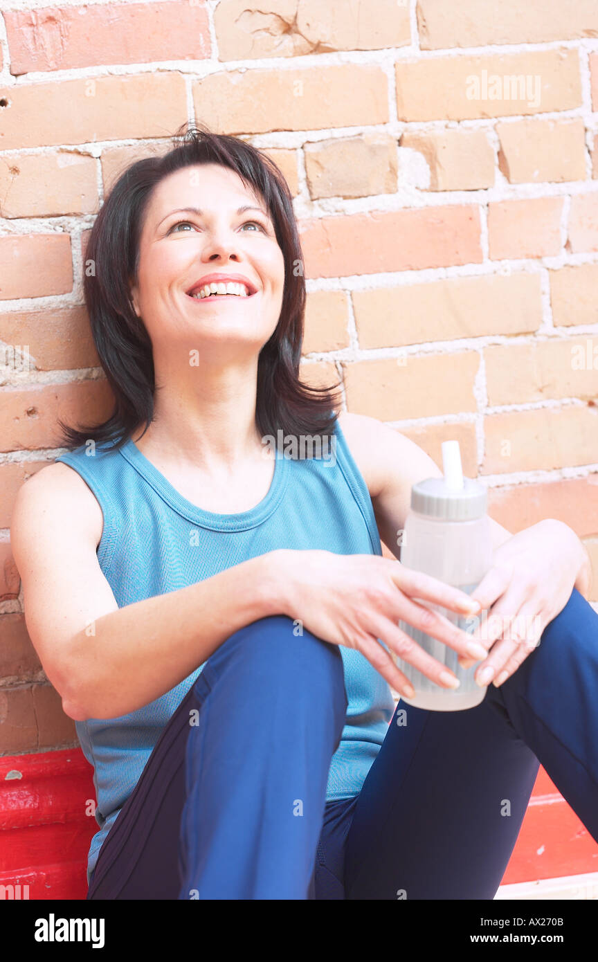 Adulto donna sorridente con la bottiglia di acqua 1427278 uid Foto Stock