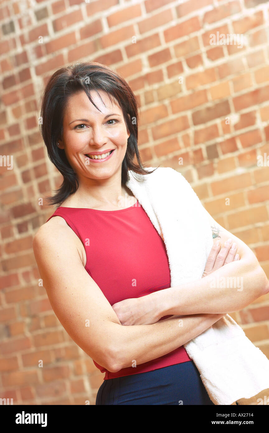 Adulto donna sorridente con asciugamano e braccia incrociate uid 1427292 Foto Stock