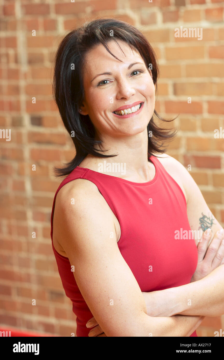 Adulto donna sorridente con le braccia incrociate 1427297 uid Foto Stock