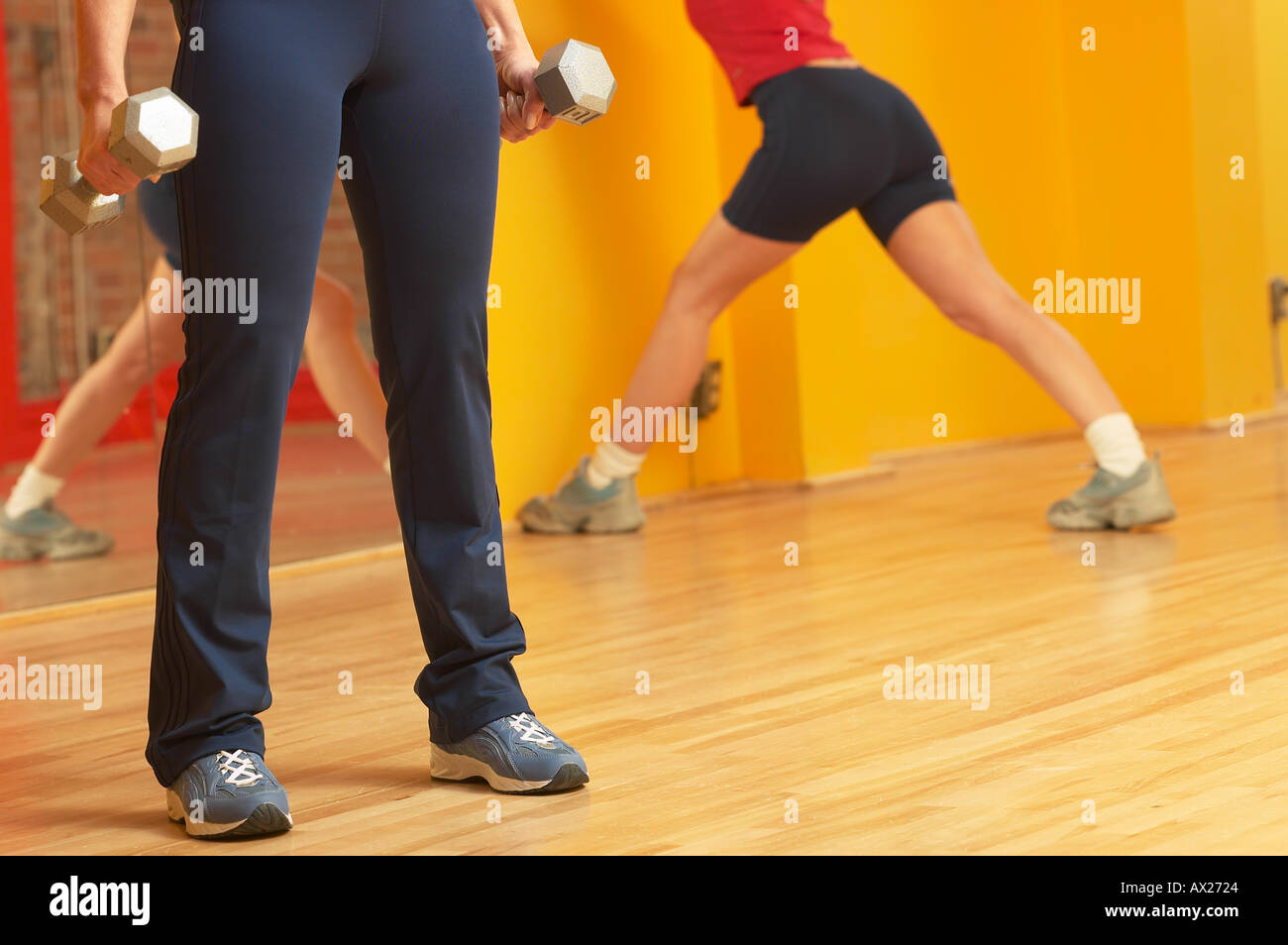 Coppia donna adulta sollevamento pesi con la donna lo stiramento in background 1427309 uid Foto Stock