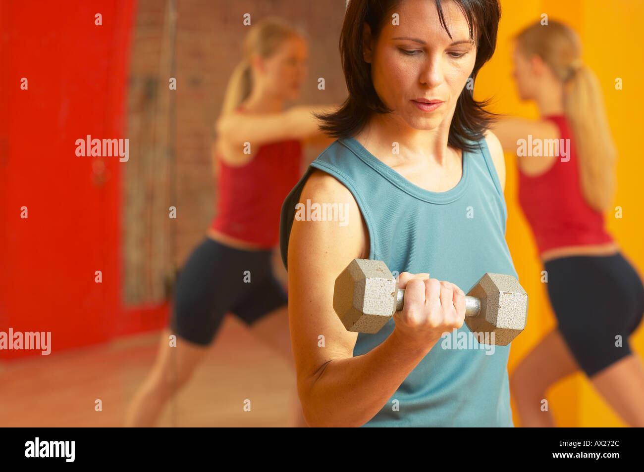 Coppia donna adulta sollevamento pesi con la donna lo stiramento in background 1427314 uid Foto Stock