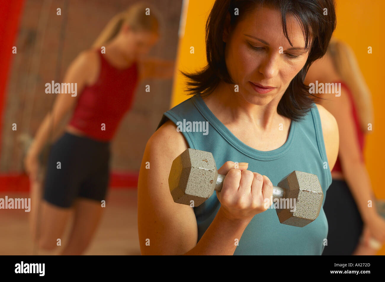 Coppia donna adulta sollevamento pesi con la donna lo stiramento in background 1427316 uid Foto Stock
