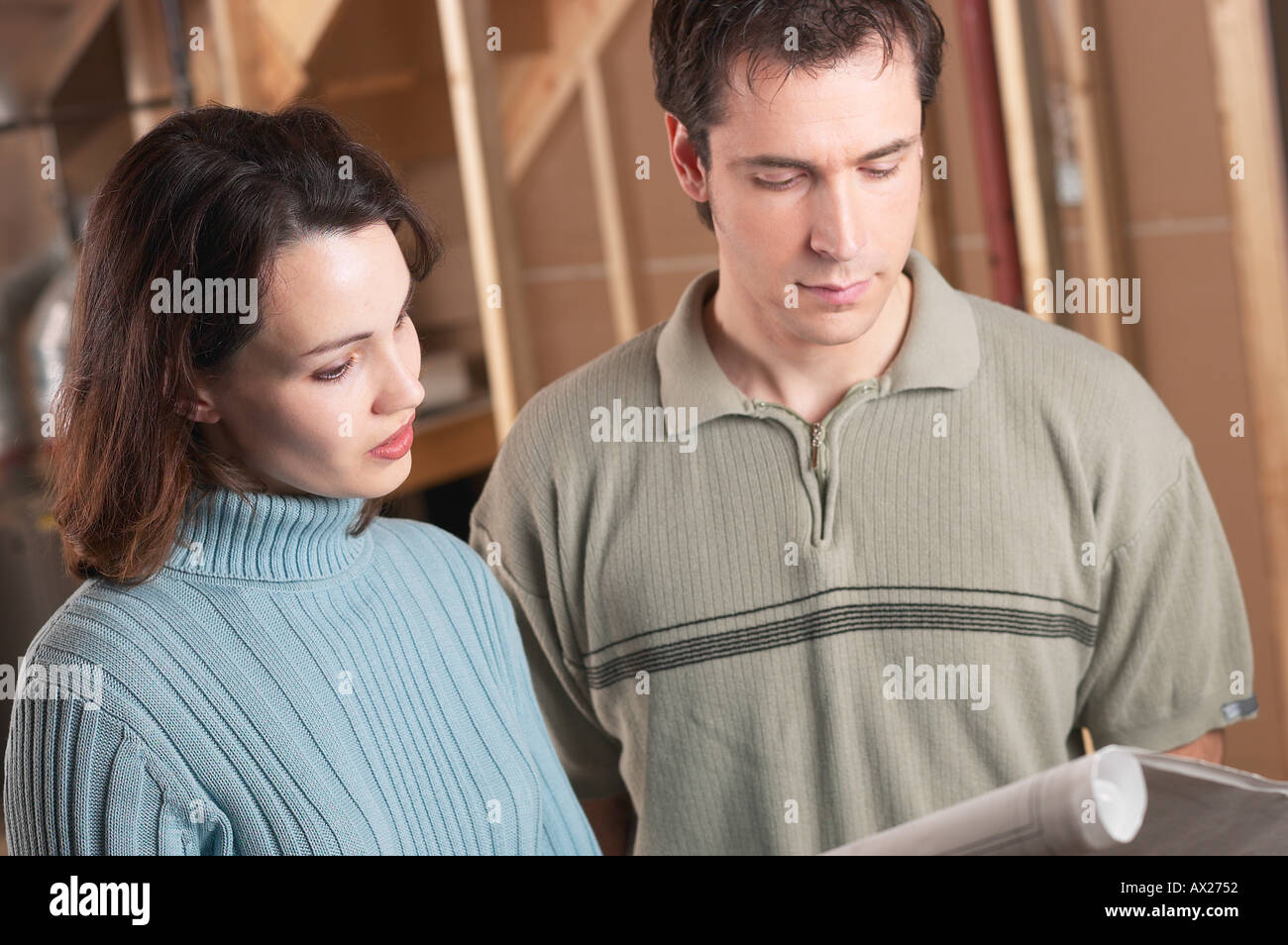 Adulto Giovane guardando le stampe blu in casa in costruzione 1427450 uid Foto Stock