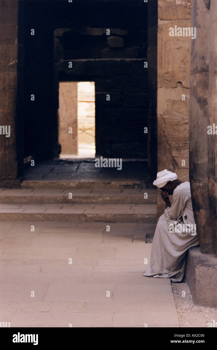 Uomo egiziano seduta del Tempio di Luxor in Egitto Foto Stock