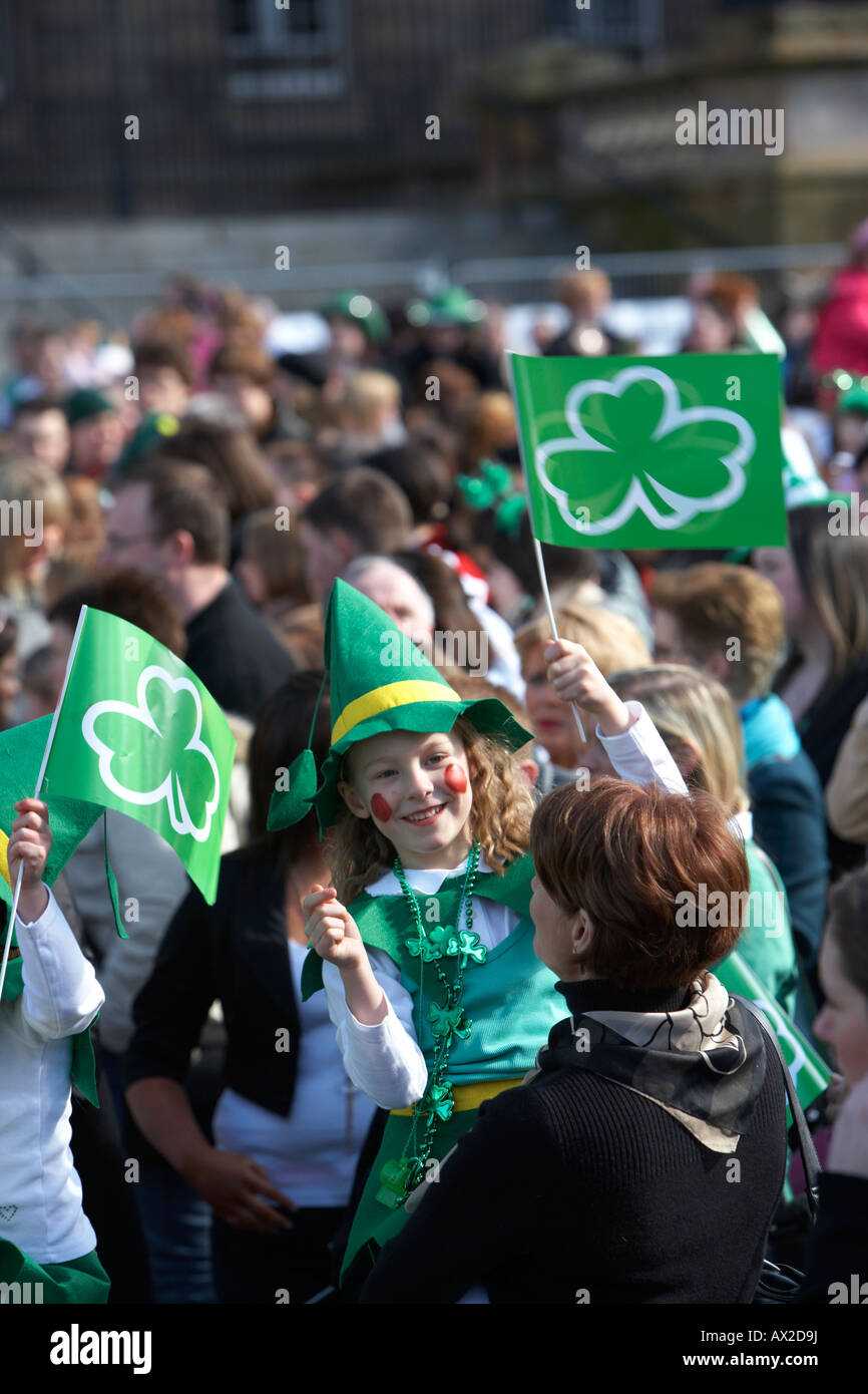 Giovane ragazza in costume costume irlandese sventola bandiera in mezzo alla folla al concerto e carnevale in custom house square st patricks Foto Stock