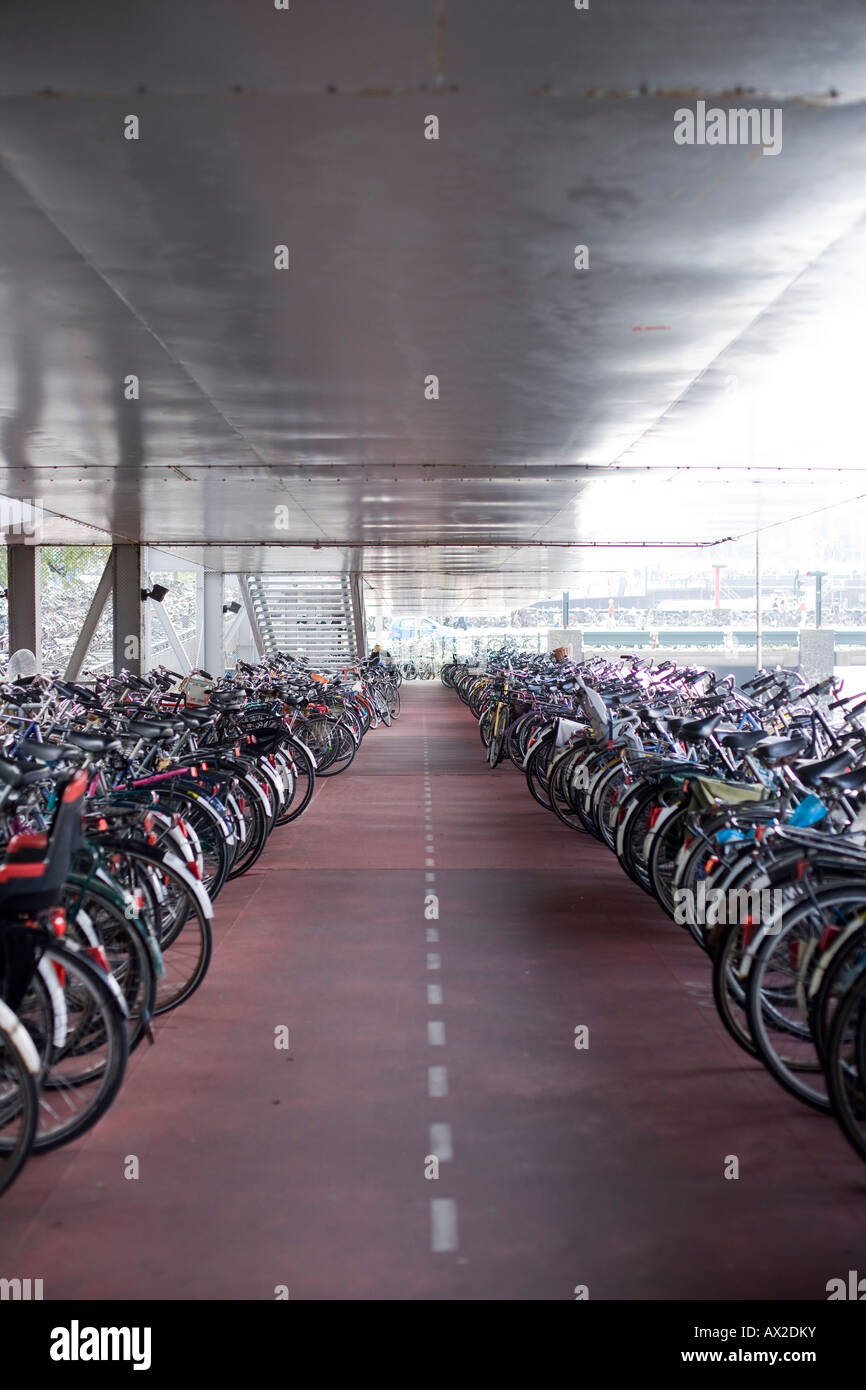 Molte biciclette parcheggiate in una grande sala e un rosso contrassegnato con il passaggio di modo Foto Stock