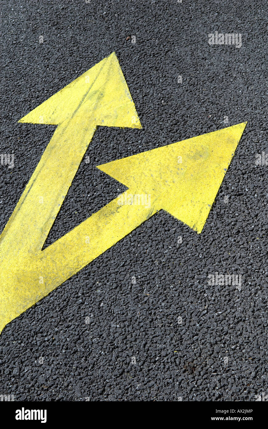 Strada asfaltata gialla con frecce di direzione Foto Stock