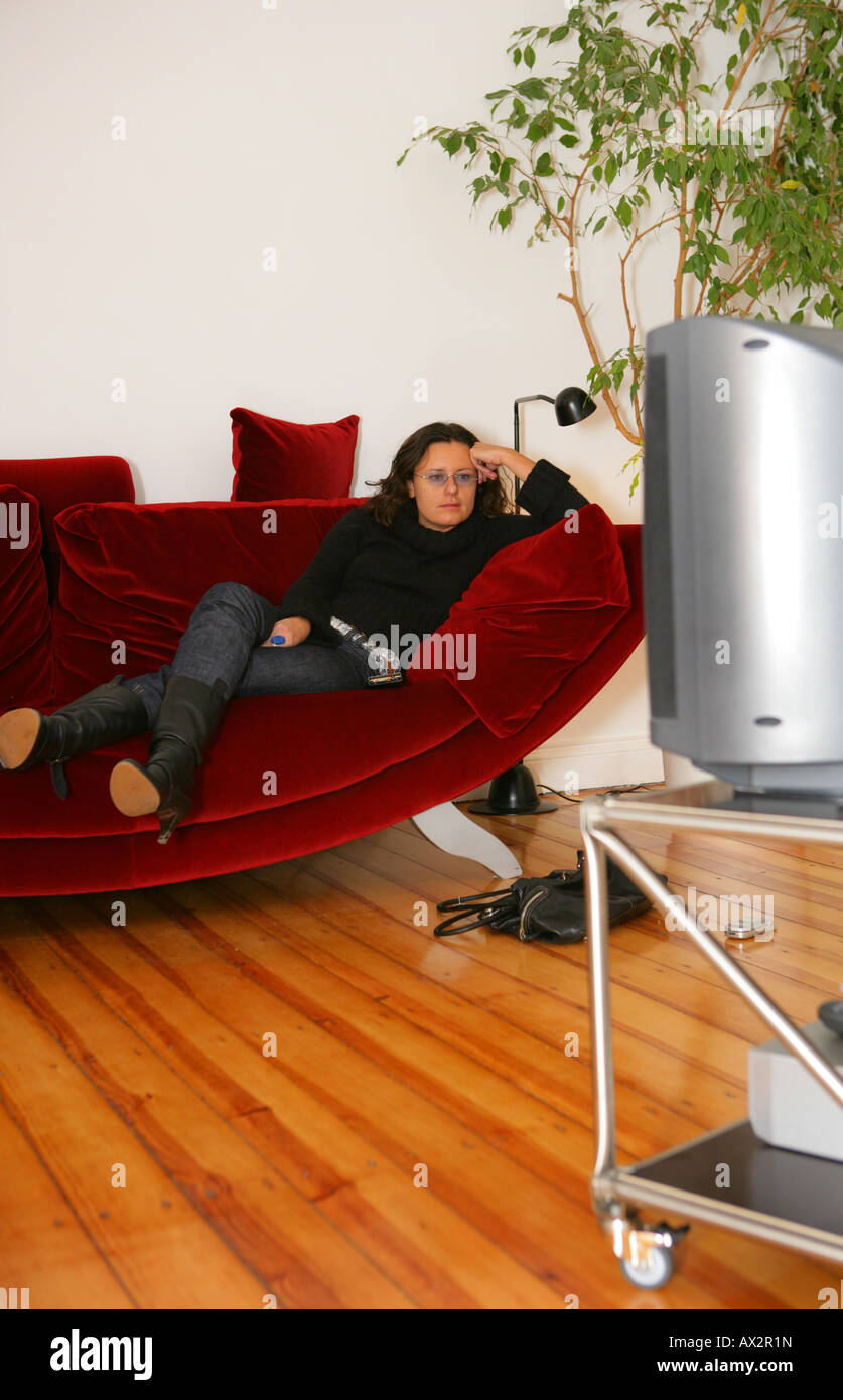 Giovane donna Orologi TV Foto Stock