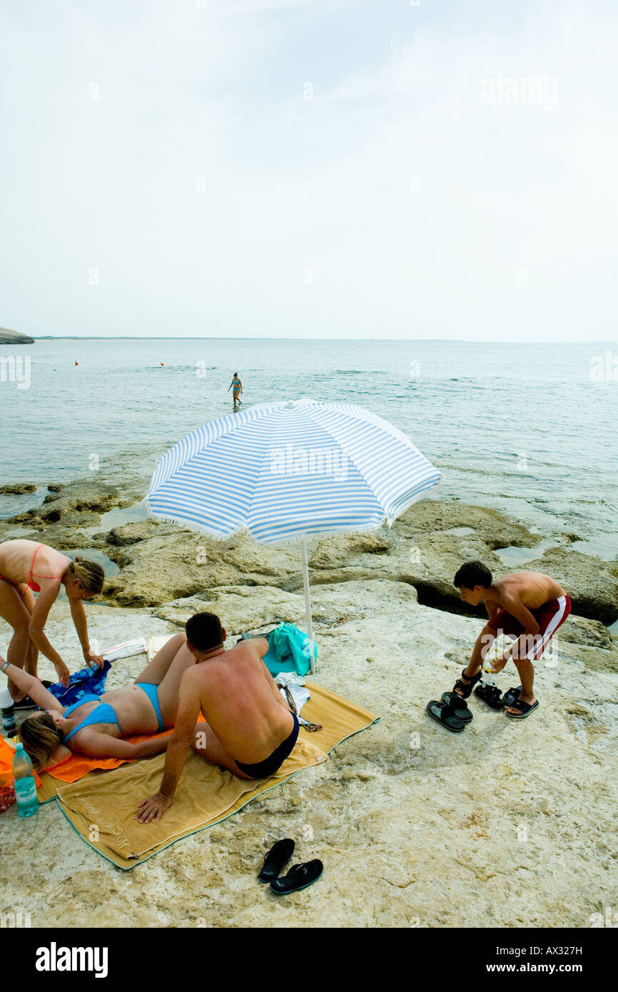 Una famiglia italiana con ombrellone sulla spiaggia vicino a Bosa Foto Stock