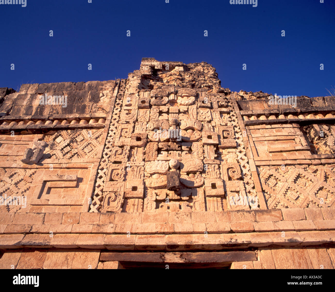 Uxmal rovine Maya Yucatan Messico dettaglio Chozas arte in pietra testa doppia i serpenti e le maschere di dio Chacón Foto Stock