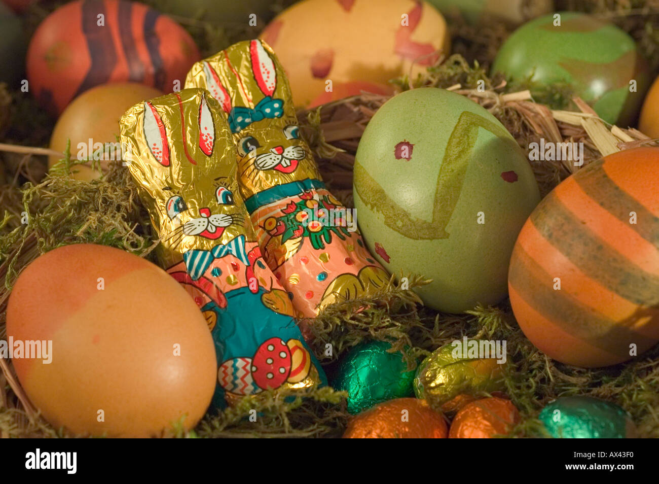 Colorate le uova di pasqua nel nido con il coniglietto di pasqua Foto Stock