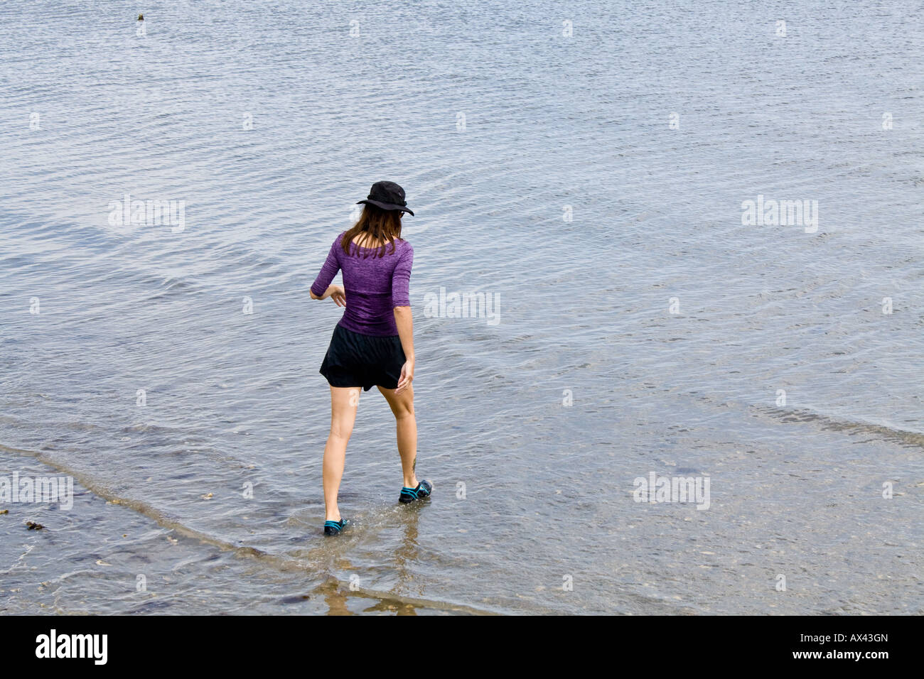 Una ragazza, completamente vestito, paddling in Matanzas River a St Augustine Florida, Stati Uniti d'America. Foto Stock