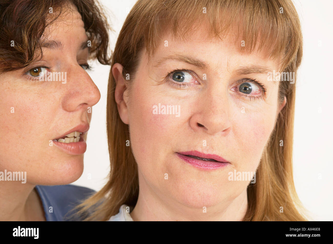 Due donne un sussurro segreto in close up di orecchio e bocca Foto Stock
