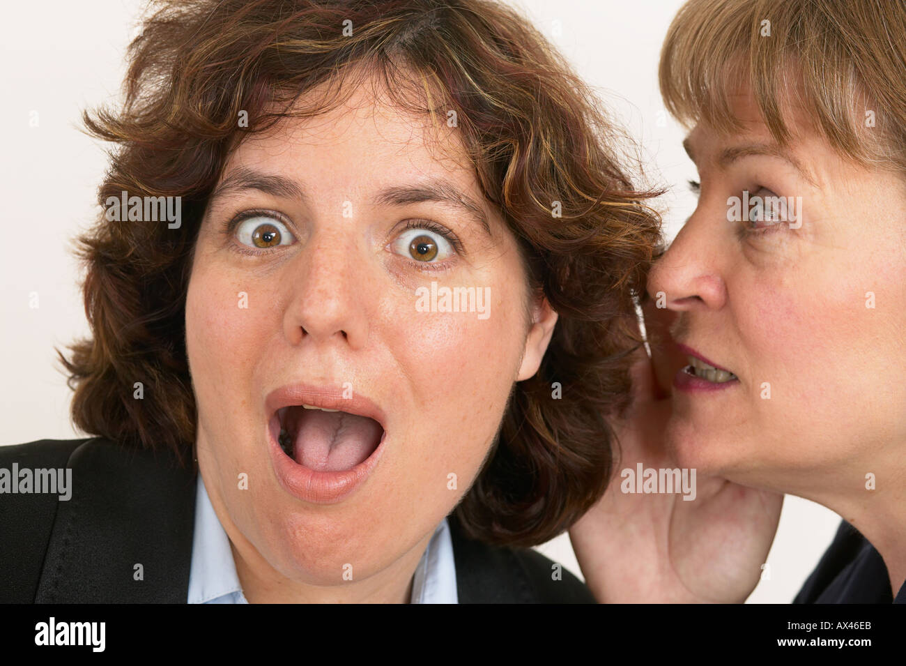 Due donne un sussurro segreto in close up di orecchio e bocca Foto Stock