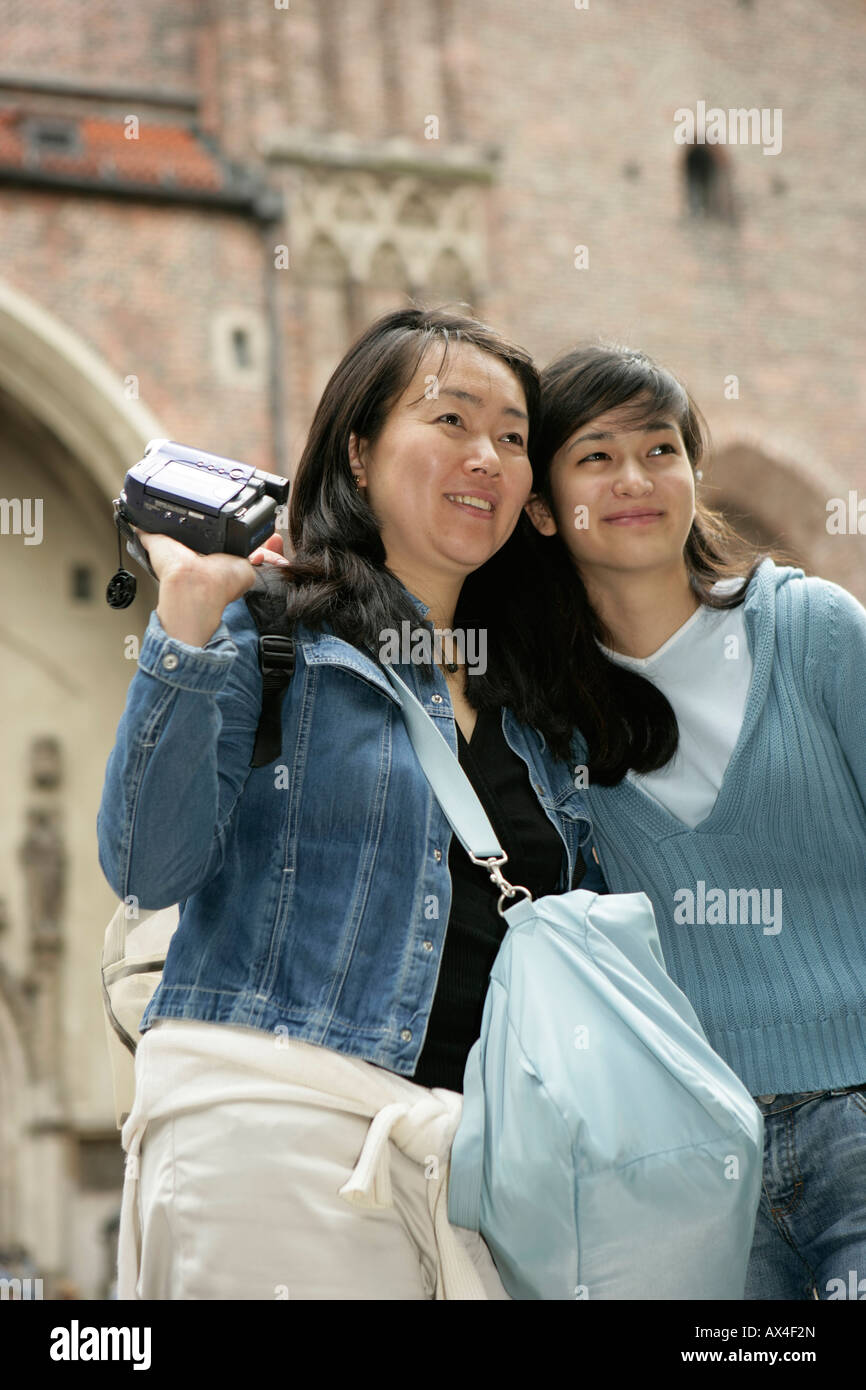 Due donne asiatiche in piedi di fronte ad un edificio medievale, il fuoco selettivo Foto Stock