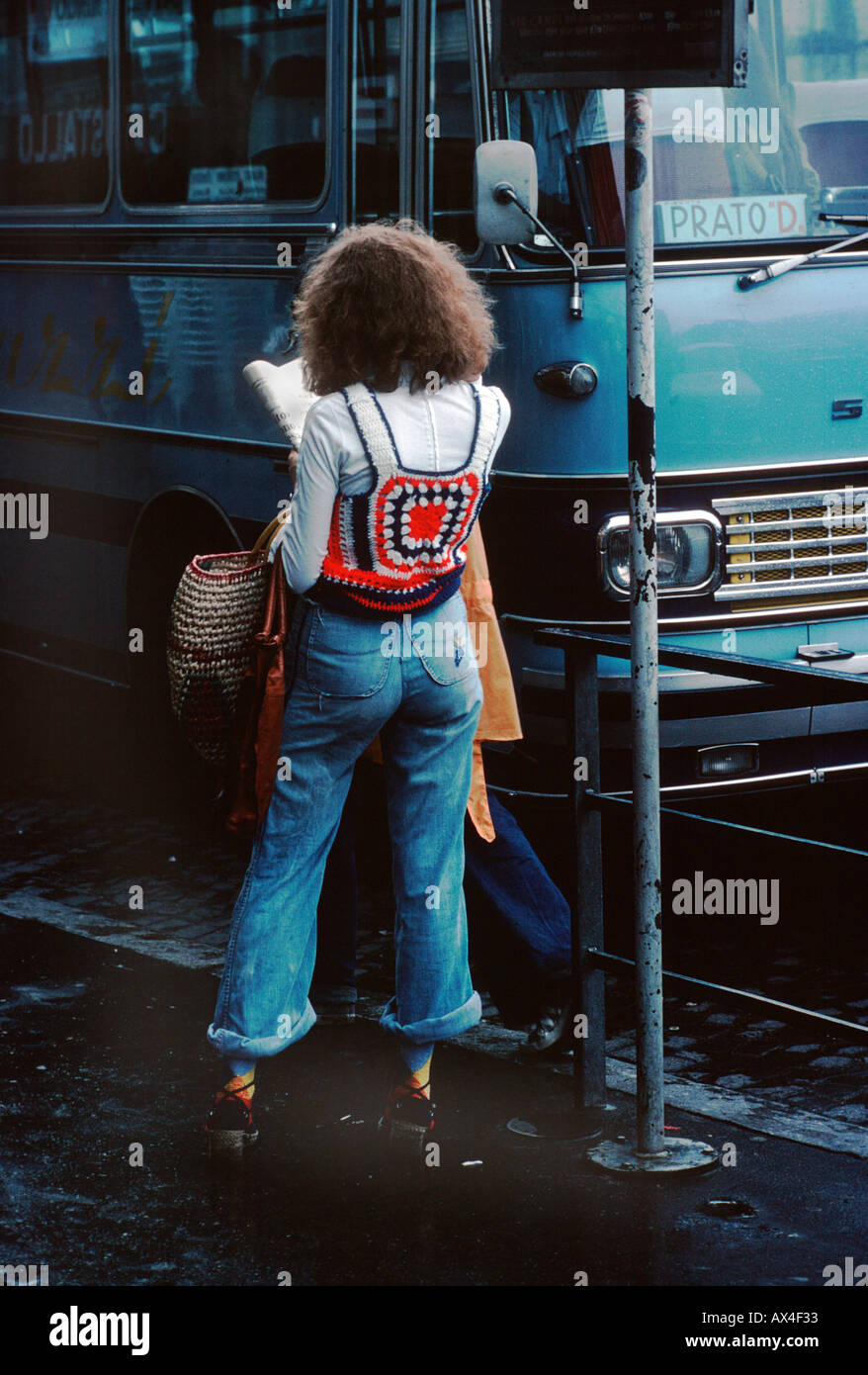 Giovane donna in jeans e un ponticello macrame visto da dietro a una fermata del bus Frlorence Italia Foto Stock