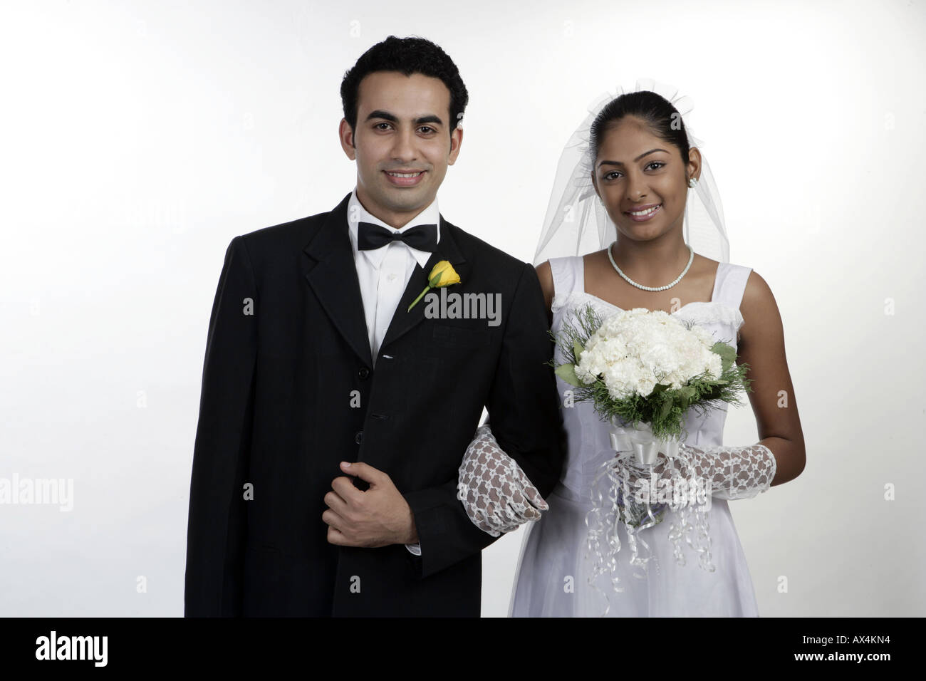 Ritratto di una sposa e lo sposo in piedi a braccetto e sorridenti Foto Stock